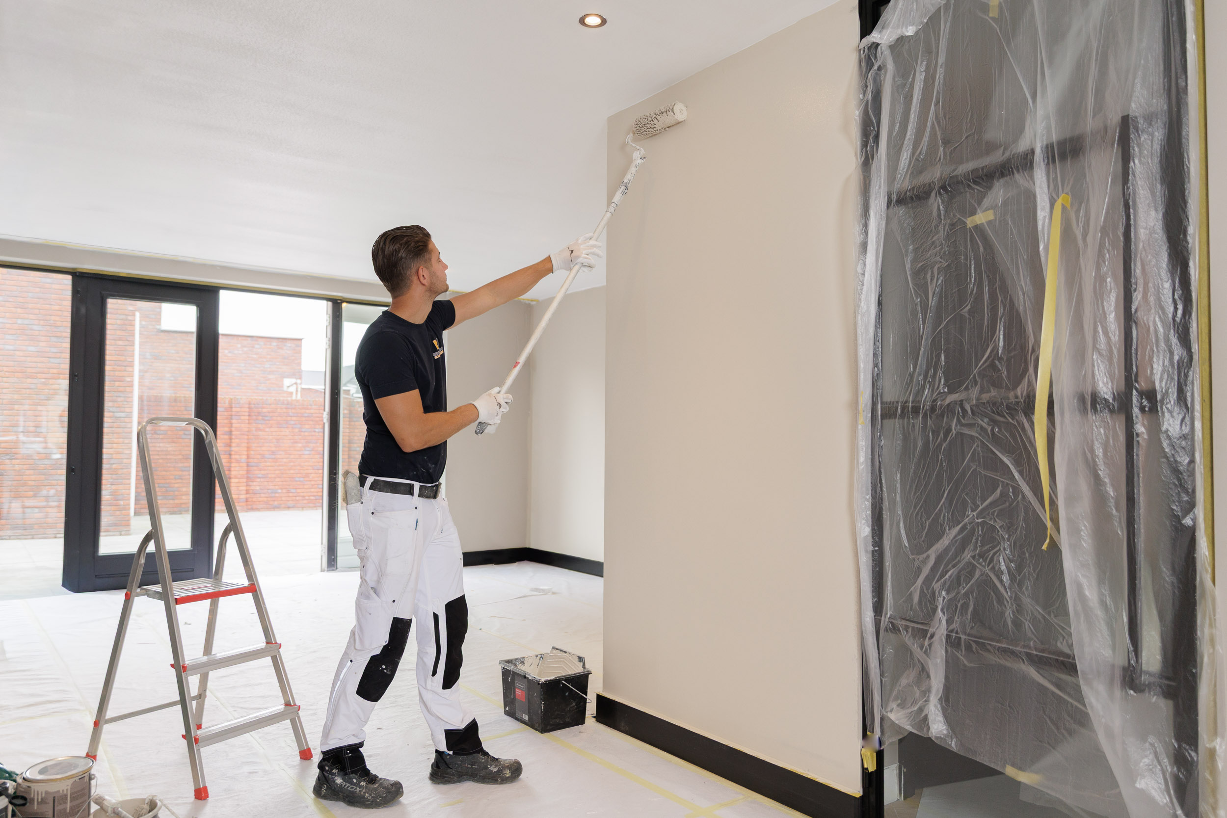 Schilder rolt een plafond in een woonkamer