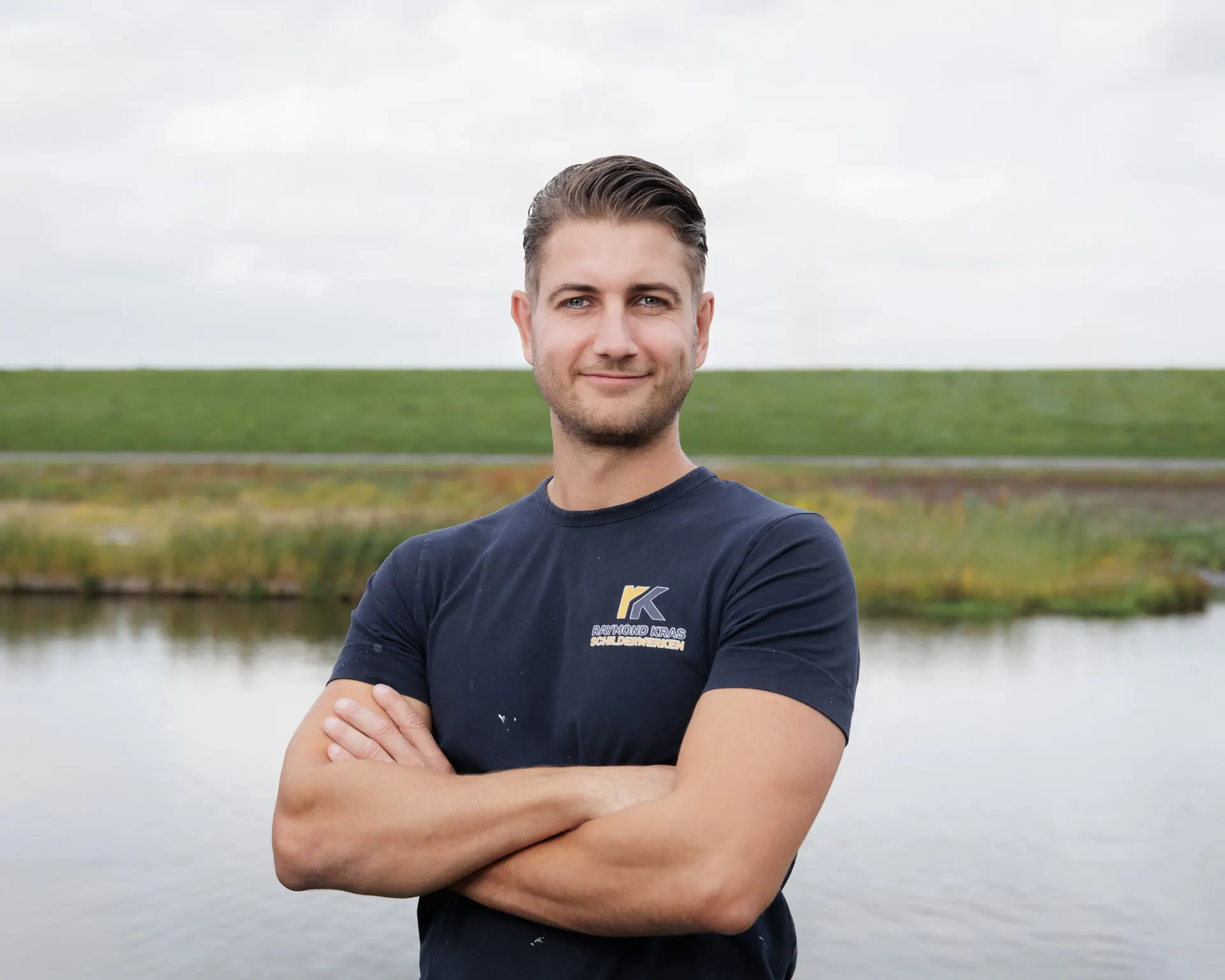 Raymond Kras van Raymond Kras Schilderwerken, staand buiten met armen over elkaar