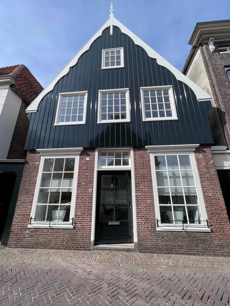 Traditionele houten topgevel in donkergroen met wit geschilderde kozijnen, huisnummer 58 in De Rijp