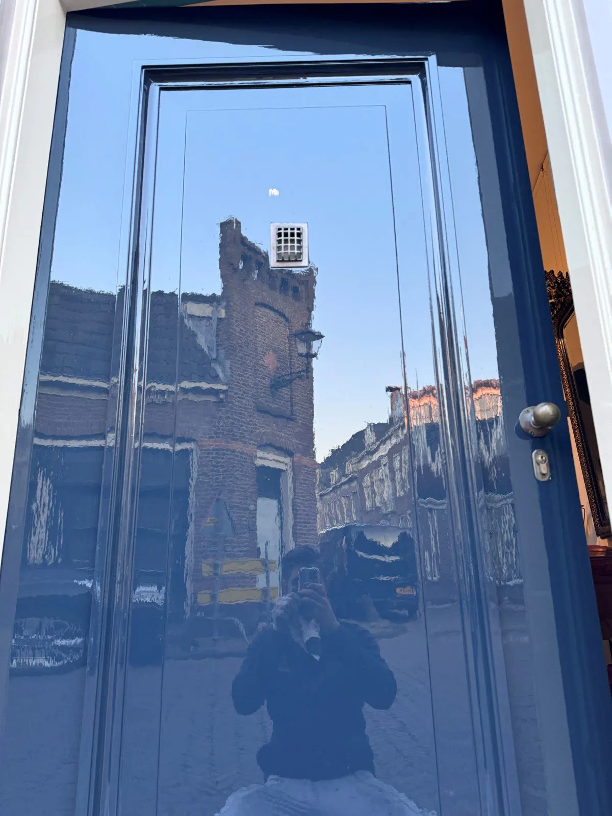 Glimmend donkerblauw geschilderde voordeur met wit kozijn, schilderproject in Edam