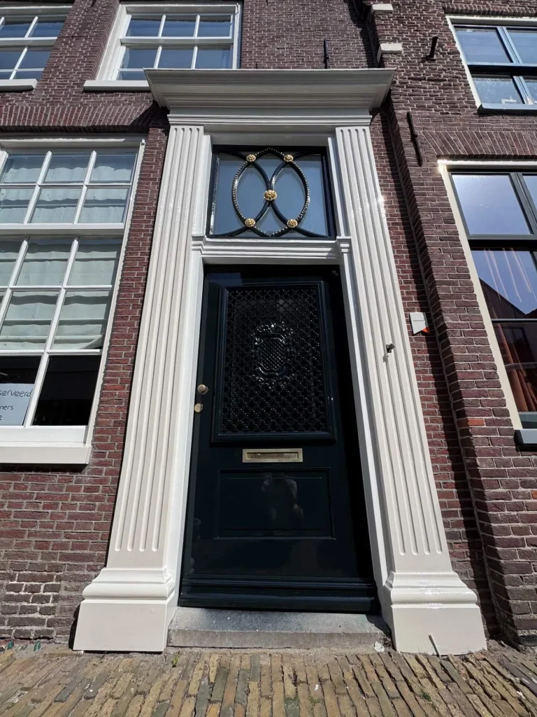 Zwart geschilderde voordeur door Raymond Kras Schilder, met sierlijk glas-in-lood bovenlicht, Kleine Kerkstraat Edam