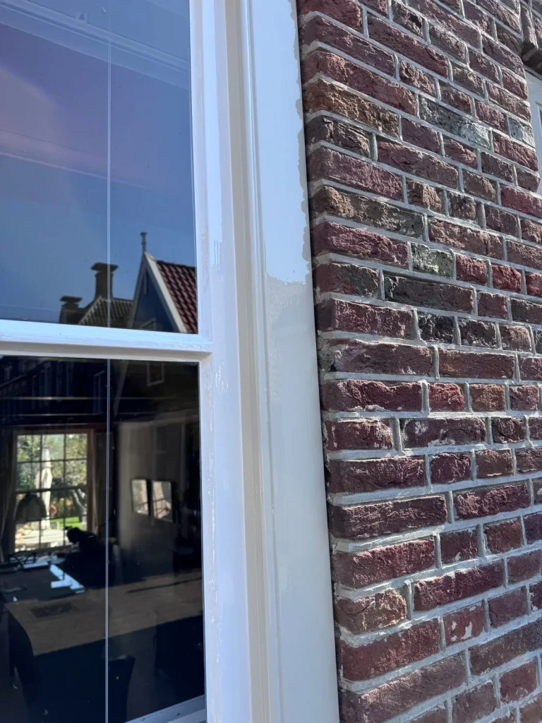Pas geschilderd wit kozijn tegen de bakstenen gevel, Edam