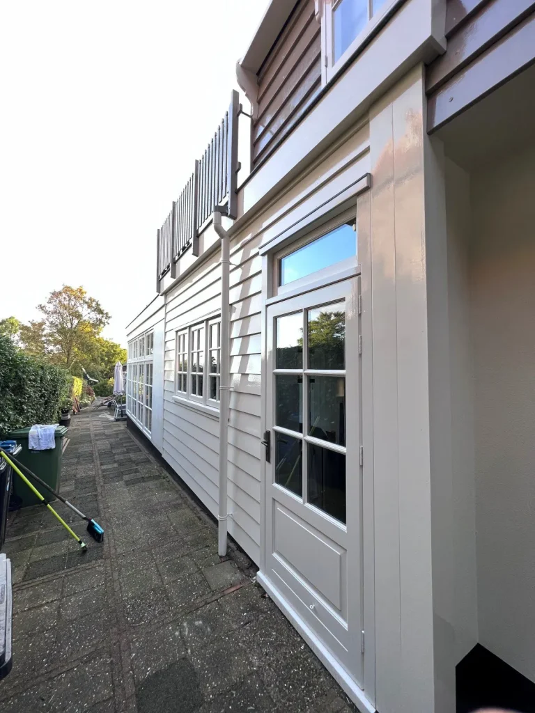 Raymond Kras Schilderwerken verzorgde dit taupe geschilderde pand met balkon en openslaande deur in De Rijp