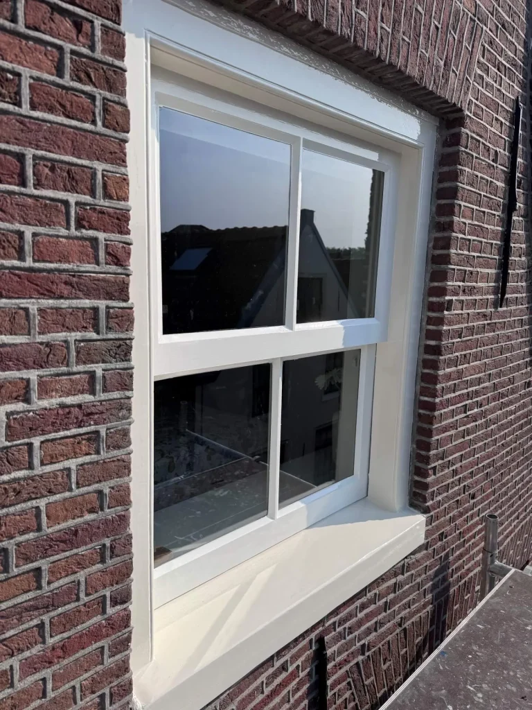 Detail van een pas geschilderd schuifraam in de bakstenen gevel, Kleine Kerkstraat Edam